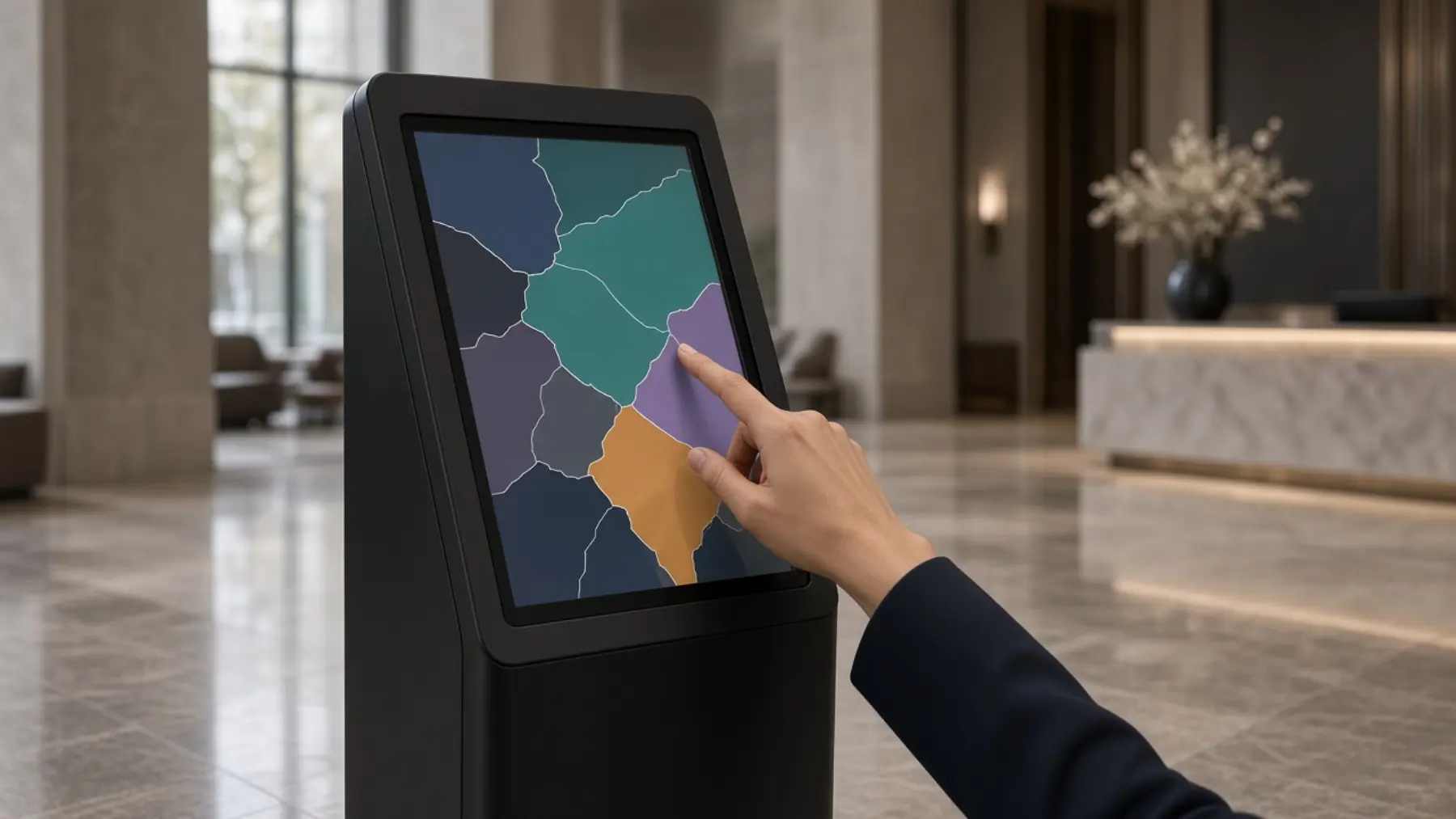 Mano tocando un kiosco de pantalla en un lobby de piedra y mármol.